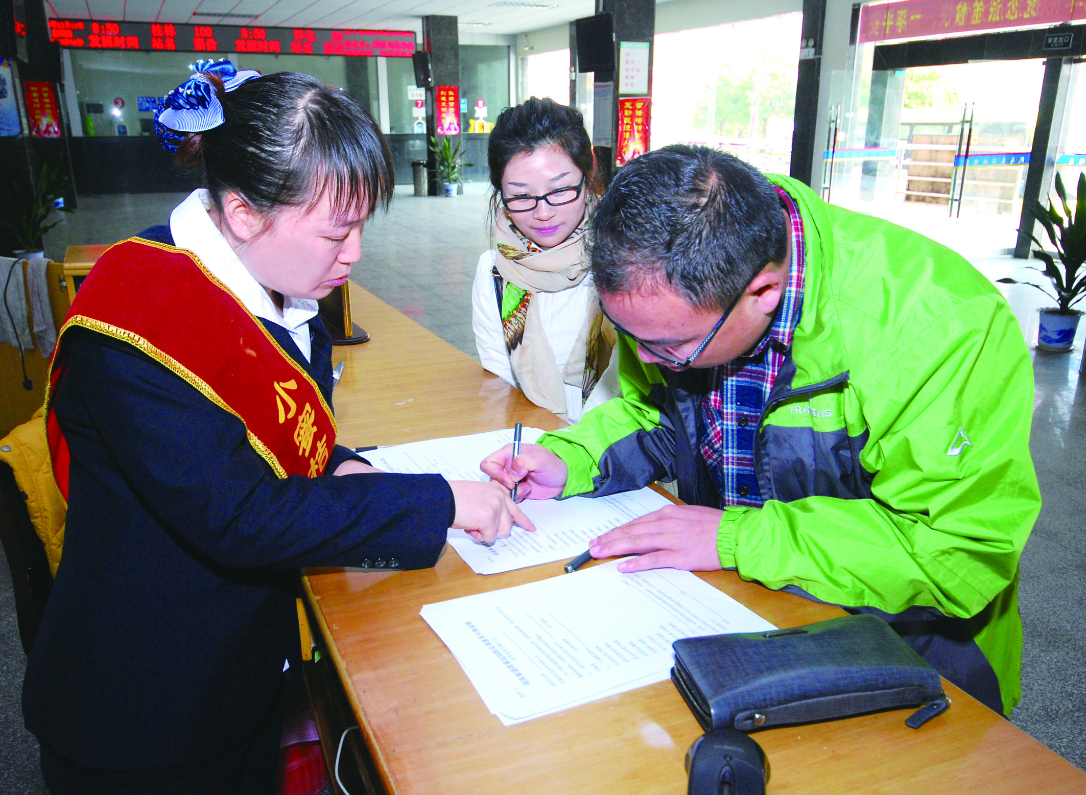 圖為洞口汽車總站站務人員在熱心為旅客服務。