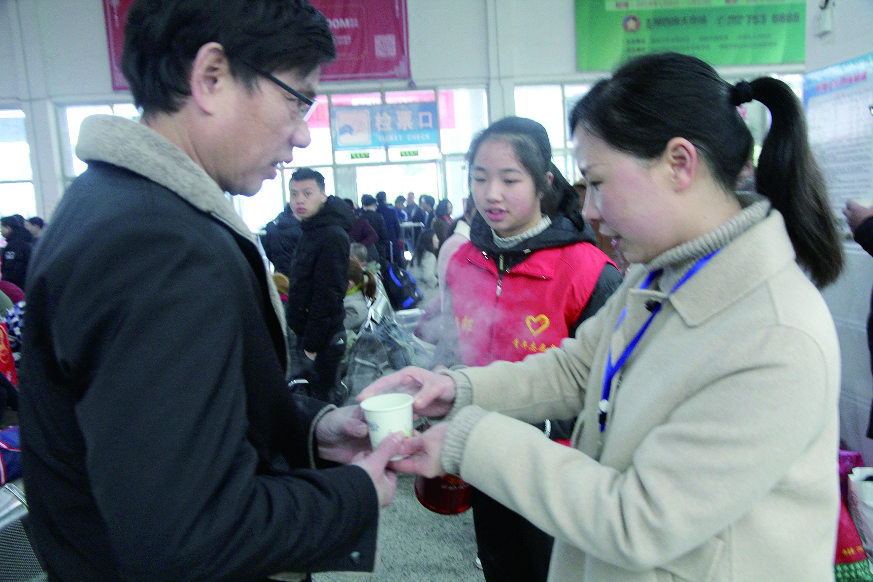 母女服務(wù)春運(yùn) 2月13日，記者在新邵分公司汽車站看到，該分公司安全科副科長(zhǎng)李喜梅與其在新邵一中初中部1701班就讀女兒劉嘉怡在車站擔(dān)當(dāng)志愿者。李喜梅在候車室耐心為旅客釋疑解惑，劉嘉怡為旅客遞上一杯杯熱茶，有時(shí)母女也相互合作，其樂融融。 祖冠 攝影報(bào)道